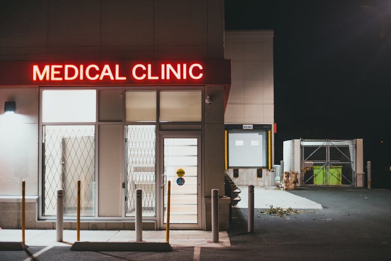 A neon-lit medical clinic entrance with no people visible, captured during the night.